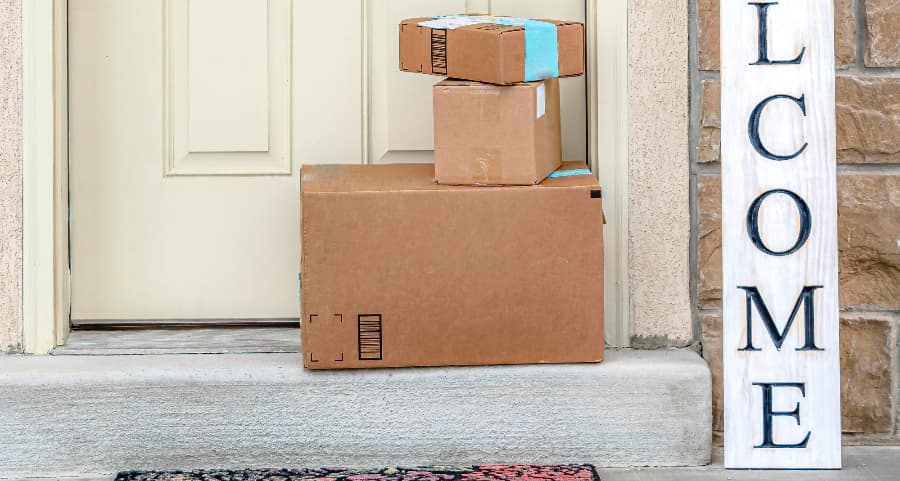 Packages on the doorstep of a home with a welcome sign in Charleston